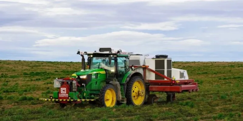 Farmer supervising tractor remotely
